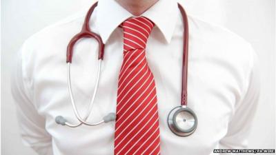 Photo of man in tie with stethoscope around his neck