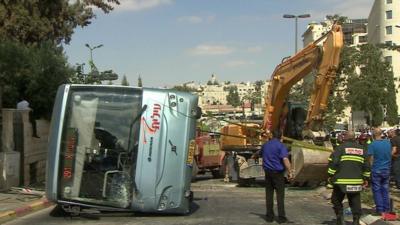 Digger and overturned bus