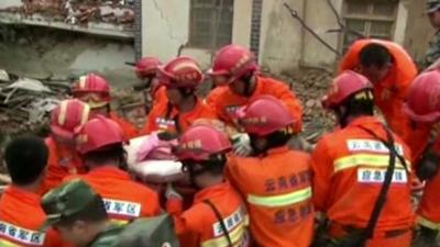 Rescue teams work through rubble