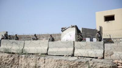 Afghanistan National Army soldiers stand guard at a gate to Camp Qargha, west of Kabul, Afghanistan