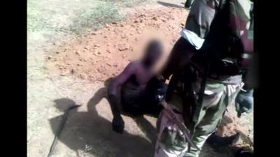 Nigerian soldier with knife and a prisoner