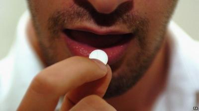 A man taking an Aspirin tablet