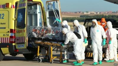 Medics load Miguel Pajares' protective chamber onto an ambulance