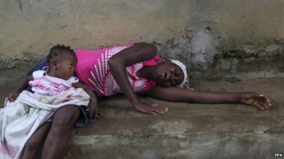 Liberian woman weeps over the death of a relative from Ebola on the outskirts of Monrovia