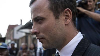 South African Paralympian athlete Oscar Pistorius leaves the High Court in Pretoria on 8 August 2014