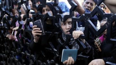 Palestinians hold their passports as they try to cross into Egypt at the Rafah Crossing, southern Gaza Strip, 10 July 2014