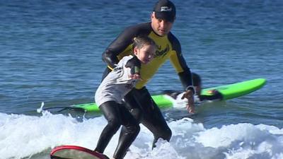Matt Grainger teaching a child to surf