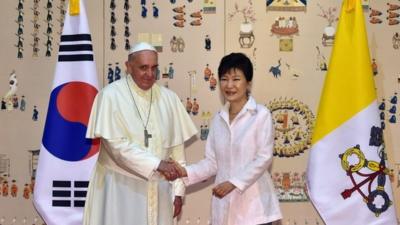 South Korean President Park Geun-Hye (R) shakes hands with Pope Francis (L)