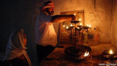Candle lighting at a Yazidi home shrine