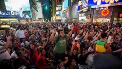 Protesters raise their arms in in New York's Times Square in a show of solidarity for shot US teenager Michael Brown