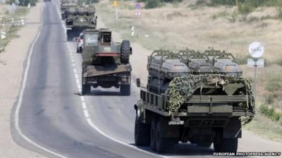 Russian armoured vehicles move along a road outside the town of Kamensk-Shakhtinsky in Rostov region, in Russia