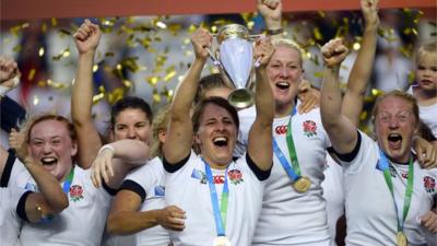 England's players celebrate with the trophy after winning the IRB Women's Rugby World Cup final match between England and Canada