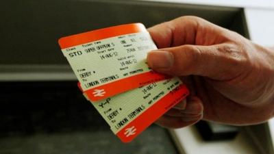 Person holding two rail tickets