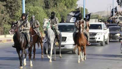 Militant Islamist fighters ride horses as they take part in a military parade along the streets of Raqqa, northern Syria, 30 June 2014