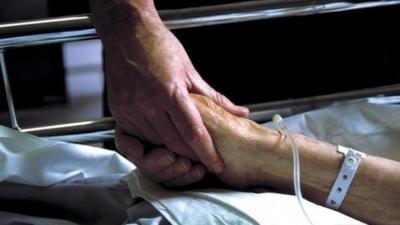 File: Holding patients hand