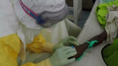 Health worker treating Ebola victim