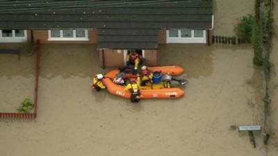 An RNLI rescue team at the door of a flooded home