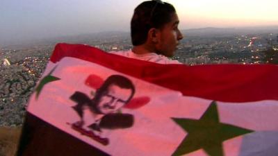 Supporter of Syria's President Assad draped in a flag