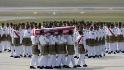 Coffins draped in the national flag were slowly carried to waiting hearses