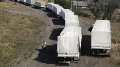 Trucks from the Russian aid convoy to Ukraine stand in line as they return to Russia