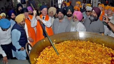 Nick Clegg stirring a curry in India