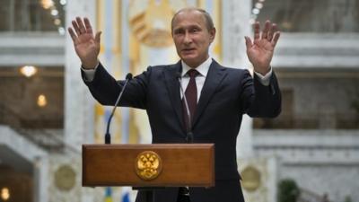 Russian President Vladimir Putin gestures while speaking to the media after his talks with Ukrainian President Petro Poroshenko in Minsk, Belarus