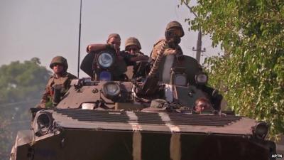 Ukrainian soldiers in a tank leaving through 'humanitarian corridor' as pro-Russian rebels advance