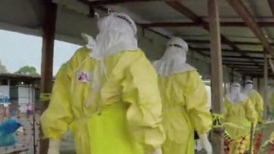 Healthcare workers in biohazard suits