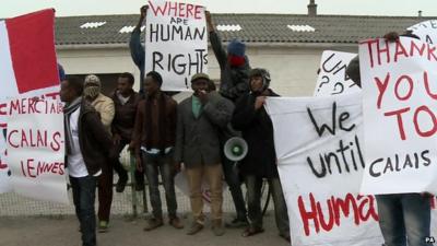 A group of migrants holding placards