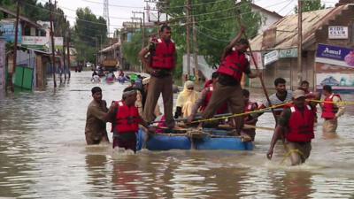 Men on a raft making their way through flood water