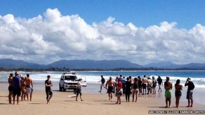 This photo taken by ABC News on 9 September 2014 shows people gathered at Australia's Clarke Beach in Byron Bay moments after the attack took place