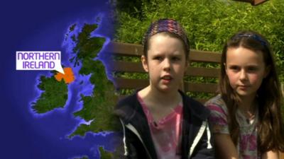 Two girls next to a map of the UK highlighting Northern Ireland