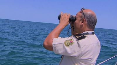 A Tunisian coast guard looks out to sea