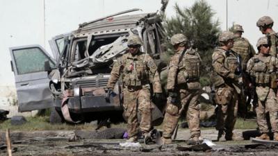 U.S. military forces inspect the site of a suicide attack near a U.S. military camp in Kabul