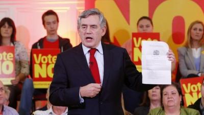 Gordon Brown holds a page from the Scotland Act 2012 during a campaign event