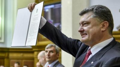 Ukrainian President Petro Poroshenko shows the Ukraine-EU Association Agreement