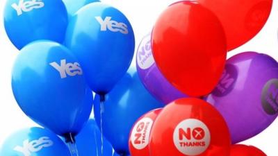 Yes and No balloons are held by people at a rally in Glasgow, Scotland, 17 September 2014