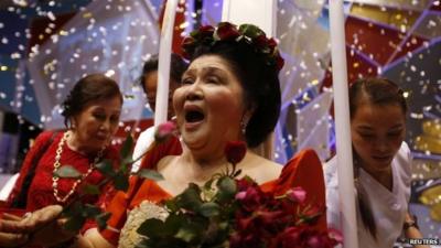 Imelda Marcos receives flowers from supporters during her 85th birthday celebration in July 2014