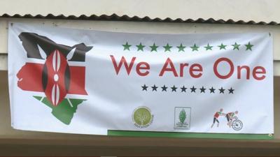 Banner reading 'We are one' with the map of Kenya in colours of the Kenyan flag