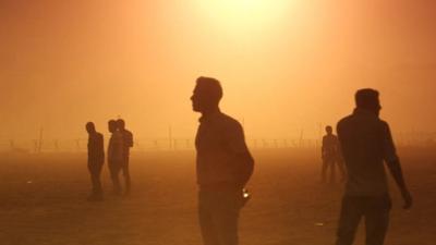 People at border in sunset