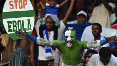 A Sierra Leone football fan with an anti-Ebola placard