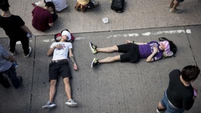 People sleep on the street as a large group of protesters block off Nathan Road, a major route through the heart of the Kowloon district of Hong Kong, on September 29, 2014