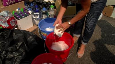 Ali Moore picking up water-soaked paper towels