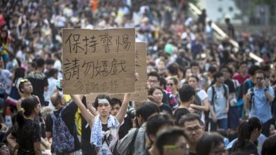 A demonstrator hold up a sign as thousands pack the streets at a protest site on October 1, 2014 in Hong Kong. Thousands of pro-democracy supporters continue to occupy the streets surrounding Hong Kong"s Financial district