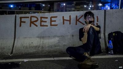 A Hong Kong pro-democracy protestor rests and checks his phone