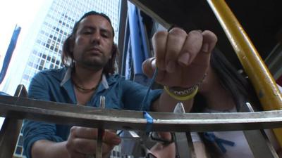 A Hong Kong resident ties a blue ribbon to a fence