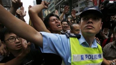 Policeman holding back protesters