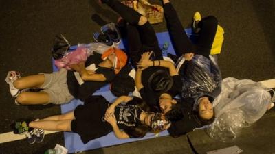 Protesters sleep on a road outside the Central Government Office in Hong Kong on October 5, 2014