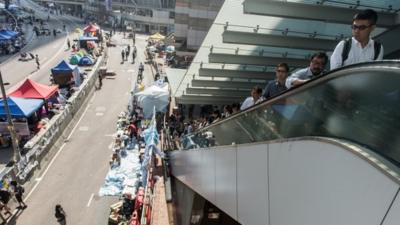 Hong Kong commuters return to work as pro-democracy protestors refuse remain on streets