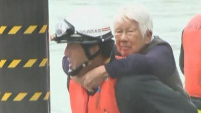 Old lady being rescued from flooding